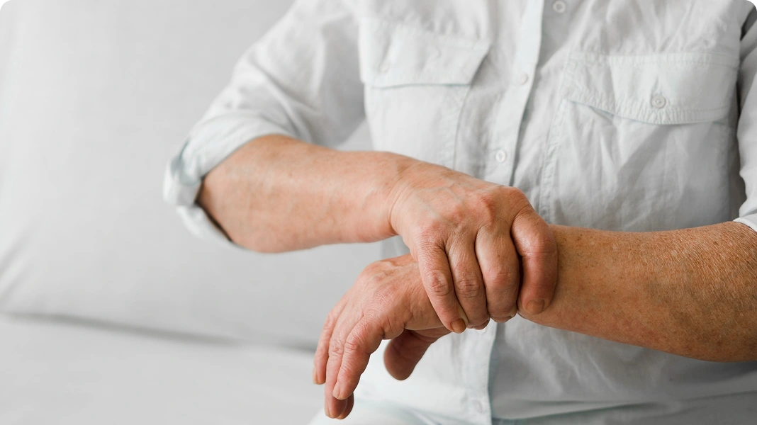 Person holding their shaking hand, showing signs of tremor.